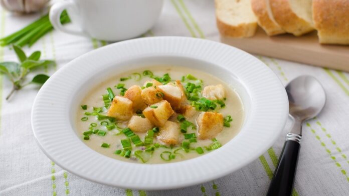 Garlic soup with croutons, spring onions and chives